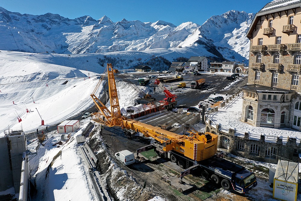 Cette photo est prise par Joël Estrade, photographe et pilote de drone basé dans les Pyrénées, Haute-Garonne, Occitanie. Il est spécialisé dans le suivi de chantiers industriels, de travaux publics, de travaux de cordistes, de chantiers en montagne et de photogrammétrie. L'image montre le plateau de la station de Superbagnères, an travaux pour la construction de la Crémaillère Express